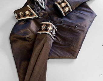 May include: A brown button-down shirt with decorative embellishments. The collar and cuffs are adorned with a pattern of clear and black gemstones. The shirt is made of a shiny, silky material.