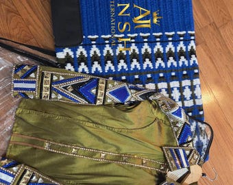 May include: A long-sleeve olive green jacket featuring intricate blue, white, and black geometric beadwork and metallic studs on the collar and cuffs, paired with a blue, white, and black patterned saddle pad labeled AJ INTERNATIONAL.