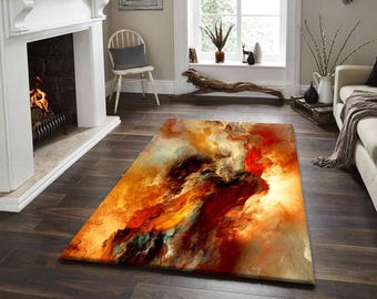 May include: A rectangular area rug with an abstract design. The rug features a blend of warm colors, including red, orange, and yellow, creating a fiery, cloud-like pattern. The rug is placed on a dark wood floor in a living room setting.