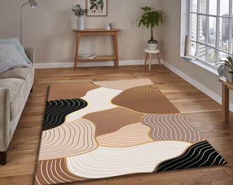 May include: A rectangular area rug with an abstract design. The rug features a pattern of curved lines and shapes in shades of brown, beige, black, and gold. The rug is placed on a hardwood floor in a living room setting.