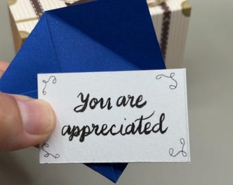 Miniatura de felicitación y recuerdo escrita a mano con la frase «Te apreciamos»