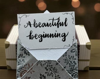Un hermoso comienzo: tarjeta de felicitación y recuerdo de boda en miniatura.