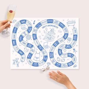 Op de afbeelding: Een wit bordspel met blauwe tekst en illustraties, getiteld "Emily's Bachelorette". Het spelbord heeft een pad met vakken voor uitdagingen en acties. Een hand houdt een champagneglas vast en een andere gooit met dobbelstenen.
