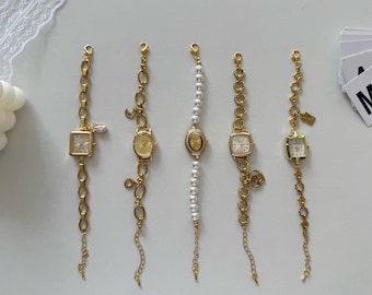 May include: Five gold-toned vintage-style bracelet watches with different face shapes and chain designs. One watch has a square face with a crystal accent, another has a pearl band, and the others have oval or square faces.