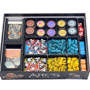 May include: A black game box filled with game components, including cards, tokens, dice, and miniature figures. The box is labeled "ARCS" with Polish text. The components are organized in black trays, with various colors and shapes.