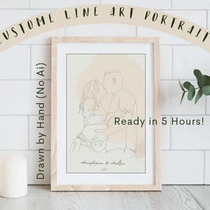 以下が含まれることがあります： 「Ready in 5 Hours!」のテキストが入った、抱き合うカップルを描いた額入りのカスタムラインアートポートレート。 アートワークは手描きで、「Anastasia & Andru」という名前と2023年が含まれています。 フレームはライトブラウンです。
