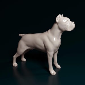 Może przedstawiać: Biała ceramiczna figurka psa w pozycji stojącej. Pies ma muskularną budowę ciała, ze szczegółowymi cechami, takimi jak głowa, uszy i ogon. Figurka jest ustawiona na ciemnoniebieskim tle.
