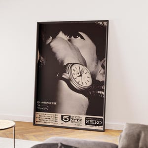 May include: Black and white framed poster featuring a close-up of a person's face with a wristwatch. The watch has a white face with black hands and markers. Japanese text and the Seiko logo are visible at the bottom.