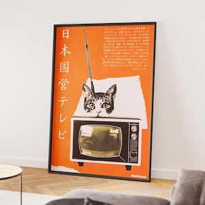 May include: A framed poster with an orange background features a vintage television with a cat's face above it. Japanese text and the words "National" are visible. The poster has a retro aesthetic.