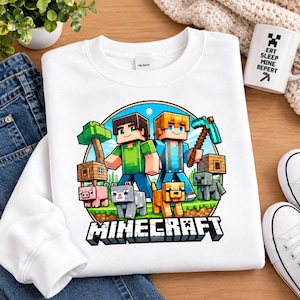 Puede incluir: Una sudadera blanca de cuello redondo con un gráfico colorido de dos personajes de Minecraft, un cerdo, un lobo y un esqueleto dentro de un marco circular. Debajo del gráfico, la palabra MINECRAFT está impresa en letras negras y blancas.