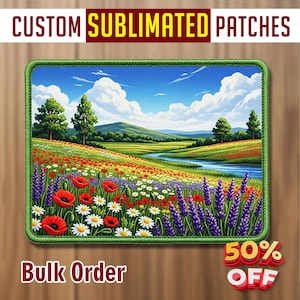Op de afbeelding: Rechthoekige, op maat gemaakte gesublimeerde patch met een levendig landschap met een rivier, wilde bloemen en bomen onder een blauwe lucht. De patch heeft een groene rand en de tekst "Bulk Order".