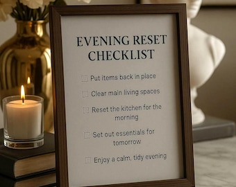 May include: A framed "Evening Reset Checklist" with a brown wooden frame. The checklist includes tasks like putting items back, clearing spaces, and setting out essentials. A lit candle and flowers are in the background.