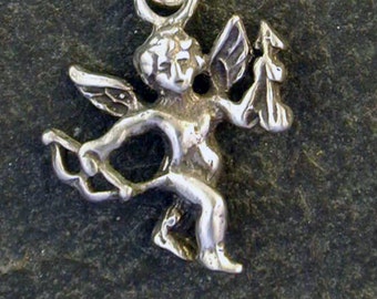 Puede incluir: Collar con dije de plata que representa a Cupido, el dios romano del amor, sosteniendo un arco y una flecha. El dije está unido a una cadena de plata.