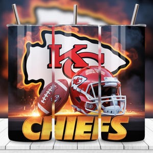 Op de afbeelding: Een roestvrijstalen beker met het logo van de Kansas City Chiefs, een voetbal en een rode helm. Het ontwerp bevat het woord "CHIEFS" in gouden letters, tegen een vurige achtergrond. Inclusief een zilveren rietje.