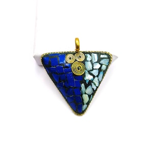 May include: A triangular pendant with a mosaic design. The pendant has a brass-coloured bail and a mosaic pattern of blue and white tiles. The mosaic is framed with a brass-coloured border and includes three brass-coloured spiral accents.
