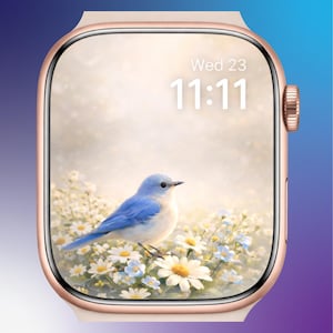 Puede incluir: Un reloj inteligente de oro rosa muestra una escena de la naturaleza con un pájaro azul entre flores blancas y azules. La pantalla muestra la hora 11:11 el miércoles. El reloj tiene una esfera rectangular con esquinas redondeadas.