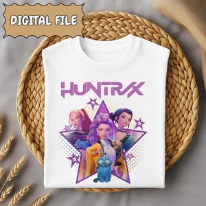 May include: White sweatshirt featuring a graphic of three animated women, a blue cat, and the word "HUNTRAX" in purple. The design is set against a star-shaped background with additional stars. The words "DIGITAL FILE" are in a banner at the top.