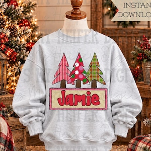 May include: A light grey long-sleeve sweatshirt featuring a graphic of three stylised Christmas trees in red, pink, and green patterns above a rectangular sign with the name Jamie in red letters. The design includes a text overlay stating INSTANT DOWNLOAD.
