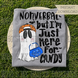 Peut inclure: Un t-shirt gris avec un fantôme blanc portant une casquette orange à motifs de toiles d'araignée. Le fantôme tient un seau citrouille bleu. Le texte noir indique : NONVERBAL but I'm Just HERE For CANDY. De petites chauves-souris sont imprimées.