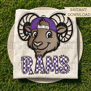 May include: A cream-colored t-shirt featuring a graphic of a brown ram wearing a purple baseball cap. Below the ram, the word RAMS is printed in a purple and white checkered pattern. The image includes the text INSTANT DOWNLOAD in the corner.