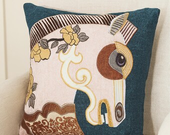 May include: Square decorative pillow with a teal blue border and a light pink center. The center features an embroidered horse head with yellow floral accents and a brown and gold decorative pattern.