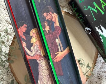 Könnte beinhalten: Drei Bücher mit illustrierten Einbänden, die romantische Szenen zeigen. Die Buchrücken sind rot, grün und schwarz. Das Buch rechts trägt den Titel "MATE" und den Namen des Autors, Ali Hazelwood. Die Einbände zeigen Paare und Waldmotive.