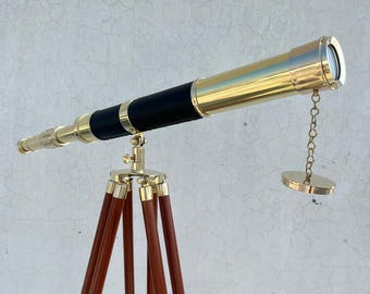 Telescopio nautico vintage in ottone su treppiede in legno, cannocchiale marino, decorazione marittima antica, complemento d'arredo in stile costiero.