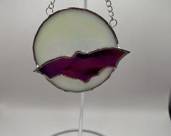 Puede incluir: Atrapasoles de vidriera con forma de luna blanca y silueta de murciélago morado. El vidrio está enmarcado con metal plateado y cuelga de una cadena plateada. Una pieza decorativa para Halloween o decoración gótica.
