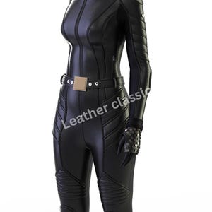 May include: A black, form-fitting jumpsuit with a high collar and long sleeves. The suit features a front zipper, a belt with a square buckle, and quilted detailing on the legs. The text "Leather classic" is visible on the garment.