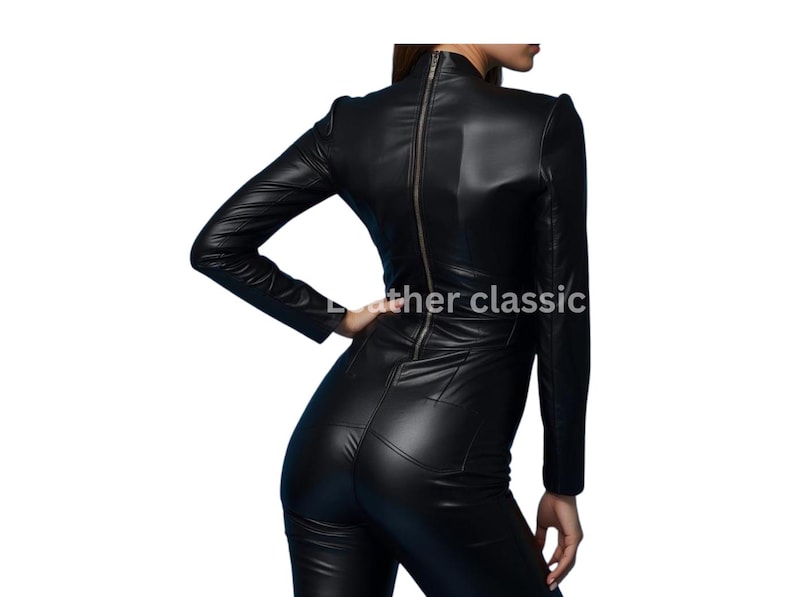 May include: A black leather jumpsuit with a high neckline and long sleeves. The jumpsuit features a full-length zipper down the back and is form-fitting. The text "leather classic" is visible on the image.