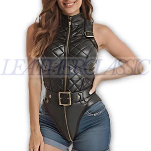 May include: A black sleeveless bodysuit featuring a quilted texture, a high mock neck, and a full-length gold-tone front zipper. The garment includes a wide integrated belt with a gold-tone buckle at the waist and a shoulder strap with a gold buckle.