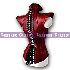 May include: A deep red corset with black lacing down the back. The corset is displayed on a white mannequin bust. The text "LEATHER CLASSIC" is printed in white on a purple banner.