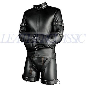 Puede incluir: Conjunto de chaqueta y pantalón corto de cuero negro. La chaqueta tiene un cuello alto con tachuelas metálicas y las mangas se aseguran con hebillas. El pantalón corto tiene tirantes y cremalleras. El texto "LEADER CLASSIC" es visible.