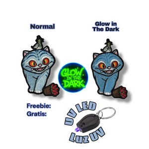 May include: Embroidered patch featuring a blue cat with a mischievous grin, wearing a hat and perched on a log. The image includes the text "Glow in the Dark" and a UV LED keychain.