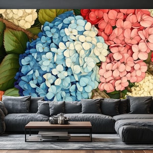 Könnte beinhalten: Ein großes Blumenwandbild mit Hortensien in Blau, Rosa und Rot. Die Blumen sind vor einem neutralen Hintergrund mit grünen Blättern angeordnet. Das Wandbild befindet sich über einem grauen Ecksofa.