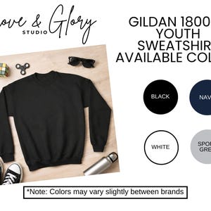 May include: A black Gildan 18000B youth sweatshirt. The image shows the sweatshirt with available colors: black, navy, white, and sport grey. The Grove & Glory Studio logo is in the top left corner.
