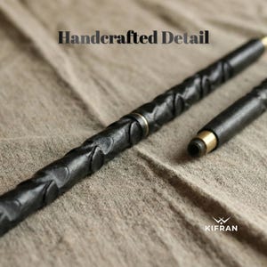 May include: A black, handcrafted pen with intricate carved details and gold-colored accents. The pen is shown in two pieces, with the tip detached. The text "Handcrafted Detail" is at the top, and the logo "KIFRAN" is at the bottom.