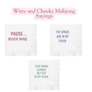 May include: Three white cocktail napkins with witty Mahjong sayings. One napkin reads "PAUSE... NEVER MIND" in red. Another says "THE WINDS ARE IN MY FAVOR" in purple. The third says "THIS HAND LOOKED BETTER IN MY HEAD" in green.
