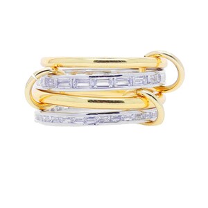 May include: A multi-band ring featuring gold and silver bands. The gold bands are smooth, while the silver bands are adorned with rectangular, clear gemstones. The bands are linked together with gold connectors.