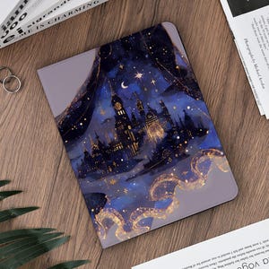 Könnte beinhalten: Eine Tablet-Hülle mit einem Nachthimmel-Design. Sie zeigt eine Schloss-Silhouette, Sterne und einen Halbmond. Das Kunstwerk verwendet Blau, Gold und Lila und schafft ein verträumtes, himmlisches Thema.