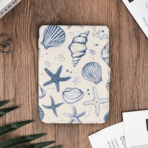 May include: A rectangular tablet case featuring a cream-colored background with a repeating pattern of blue seashells and starfish. The design includes various shell shapes and starfish, creating a nautical theme. The case is likely designed to protect a tablet.