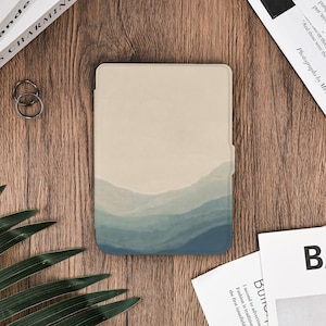 Könnte beinhalten: Eine beige und blaue Tablethülle mit Landschaftsdesign. Das Design zeigt einen Farbverlauf in Blautönen, der Berge oder Wellen darstellt, vor einem beigen Hintergrund. Die Hülle ist rechteckig und scheint aus glattem Material zu sein.