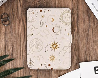 May include: A beige tablet case featuring a celestial design with suns, moons, stars, and clouds in gold. The case is rectangular and has a magnetic closure. The design is repeated across the entire surface.