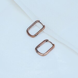 Boucles d'oreilles pendantes rectangulaires en cuivre martelé, style rustique, faites main, bijoux bohèmes artisanaux.