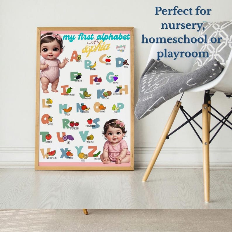 May include: A framed alphabet chart with the text "my first alphabet with Sophia" and illustrations of fruits and babies. The chart is in a light wood frame and is designed for a nursery or playroom.
