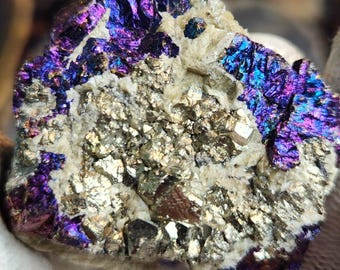 Mineral de pavo real (bornita y calcopirita) con pirita sobre calcita.