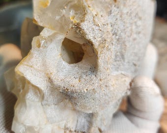 Schitterende handgesneden kwartsschedel met druzy en natuurlijke kristalformaties.