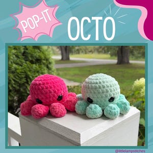 May include: Two plush octopus toys made of soft yarn, one in bright pink and one in light mint green. Each octopus features large black plastic eyes and multiple rounded tentacles. The text POP-IT OCTO is displayed above the toys.