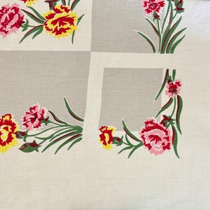 May include: A vintage tablecloth with a repeating floral pattern. The flowers are in shades of red, pink, and yellow, with green stems and leaves. The background is a light cream color with a grid pattern.