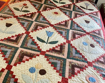 Vintage handmade quilt, log cabin and appliqué flower blocks, cotton & thin batting. Shown on double bed. Country farmhouse primitive boho